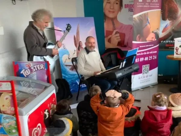  Animation musicale au cinéma d’Altkirch avec deux professeurs de La Clé de Sol entourés d’enfants lors du festival Les Petites Bobines.